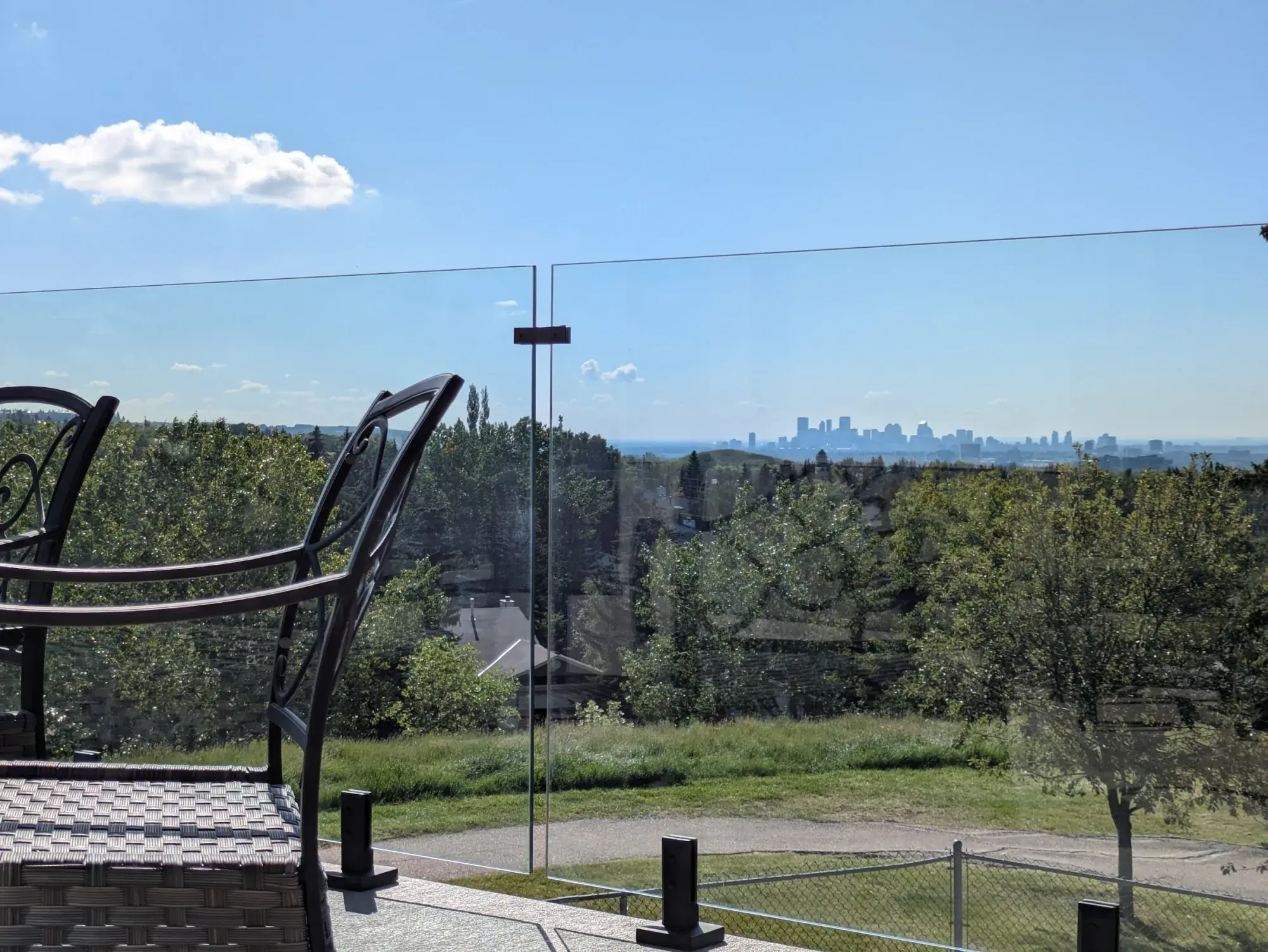 A Calgary vinyl deck with seating, downtown on the horizon beyond the trees