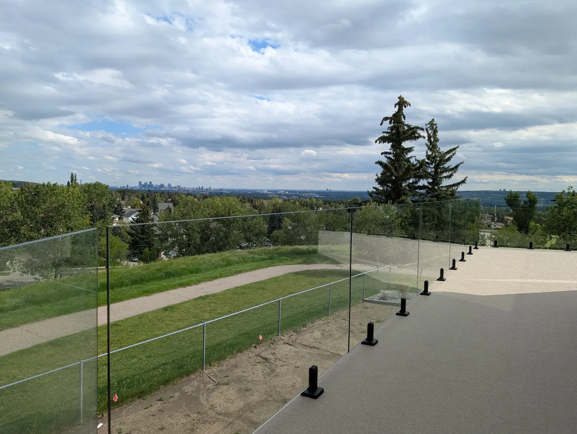 A granite vinyl deck above a pathway, the Calgary skyline on the horizon