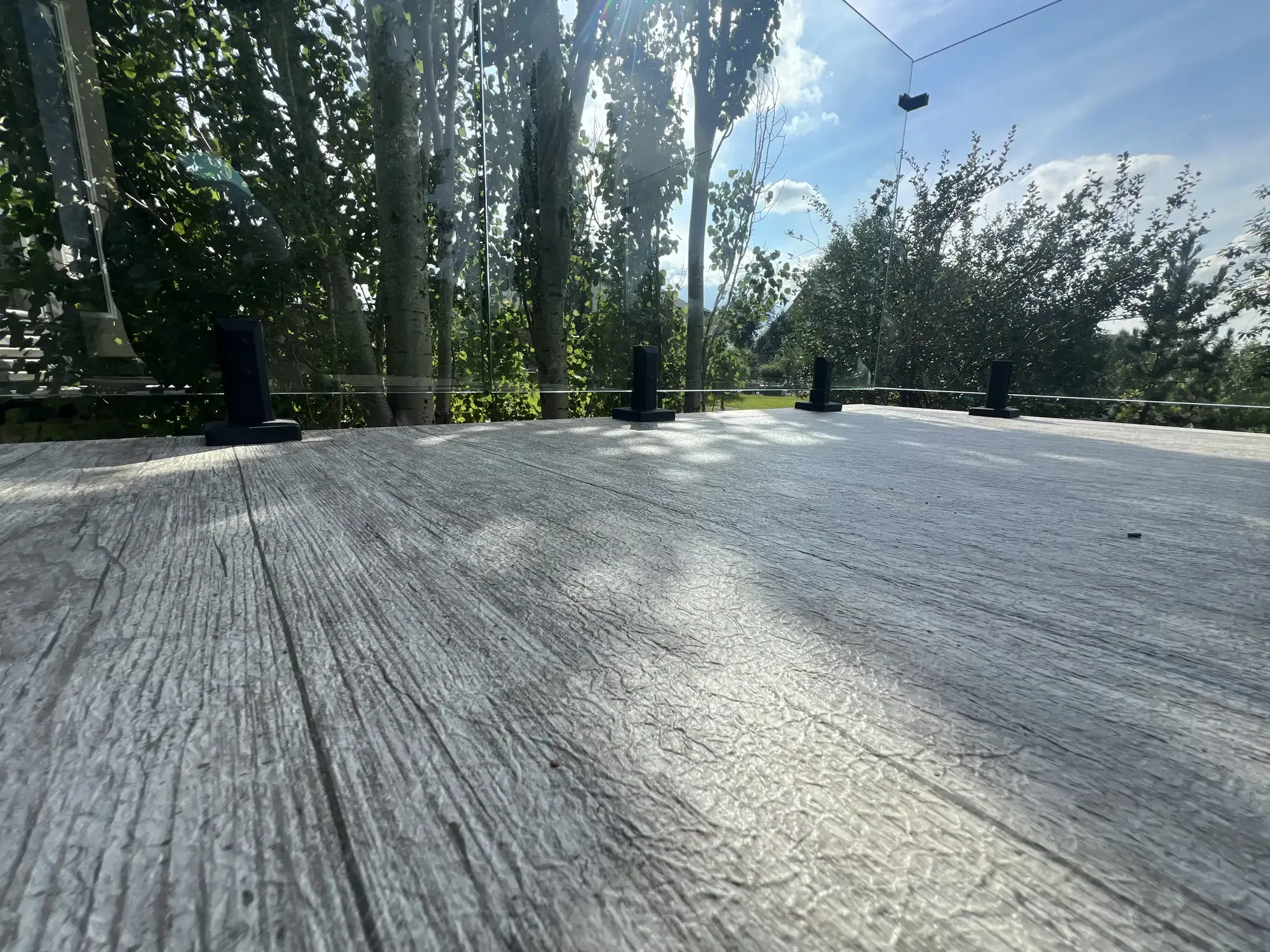 A woodgrain vinyl deck surface photographed low, showing the grain running away