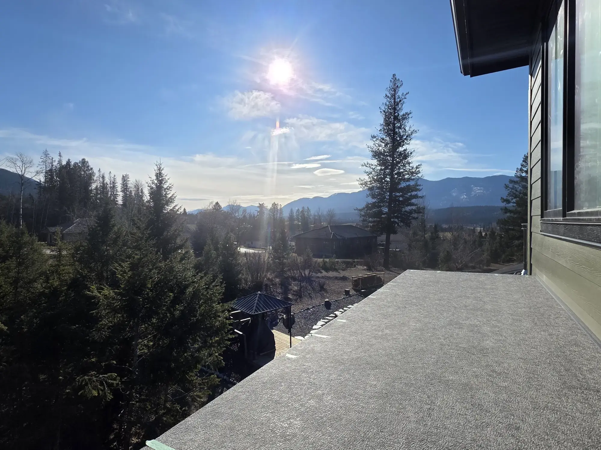 A finished vinyl deck between stone pillars, looking out toward the mountains