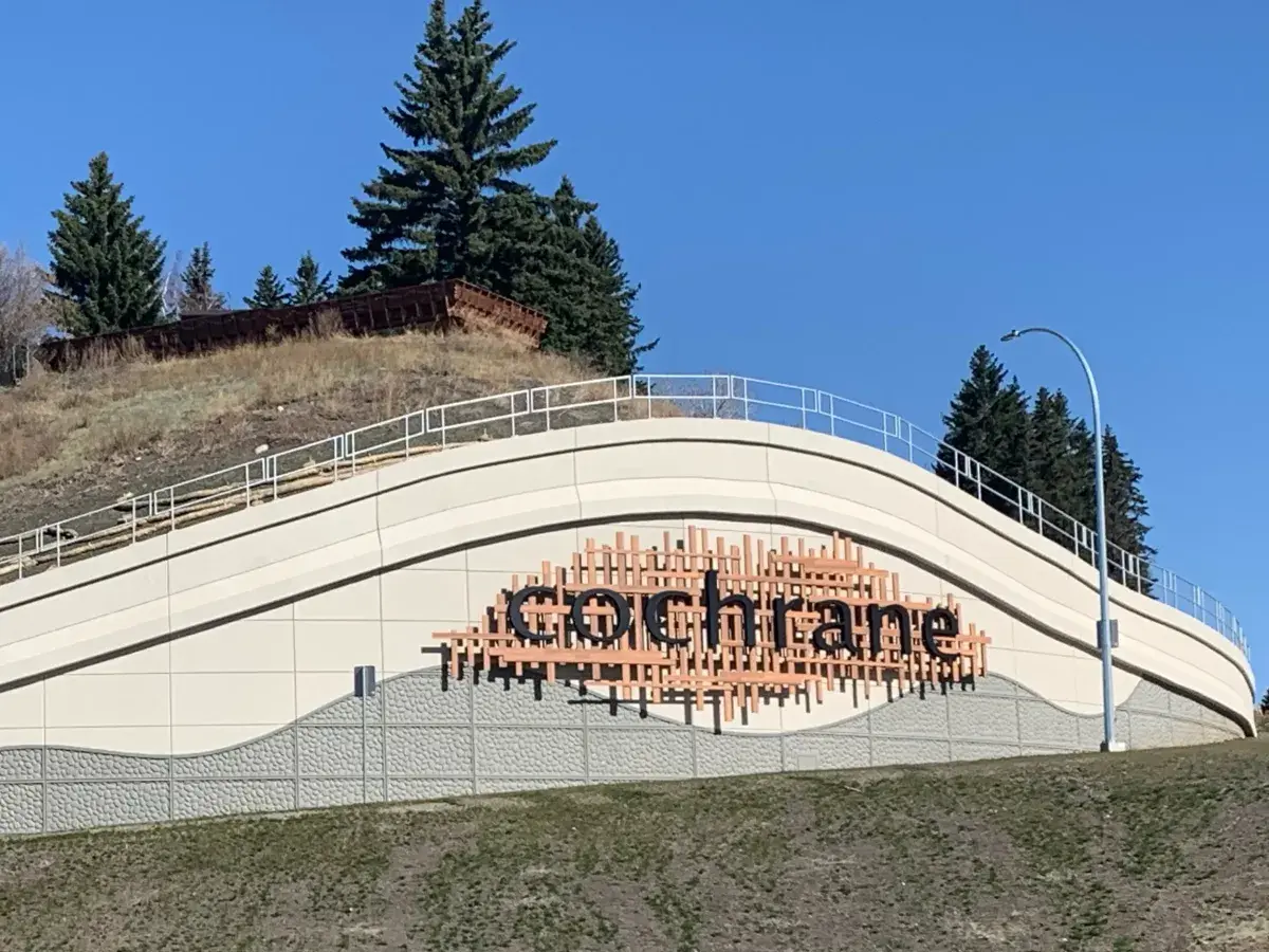 The Cochrane town gateway sign on the hillside at the edge of town